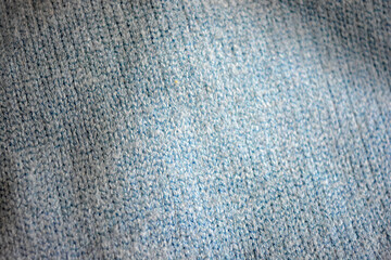 Knitted products, light blue women's woolen sweater with interesting patterns, knitting in the form of a braid, gathered elastic, different weaves and stitching.