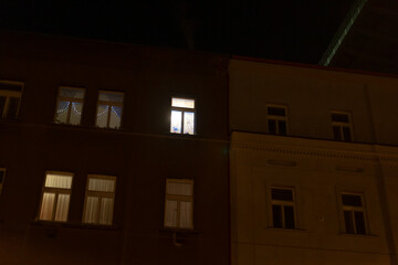 A large building adorned with numerous windows is beautifully illuminated at night, glowing brightly against the dark sky
