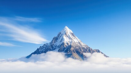 Majestic snow-capped mountain rising above the clouds under a blue sky.