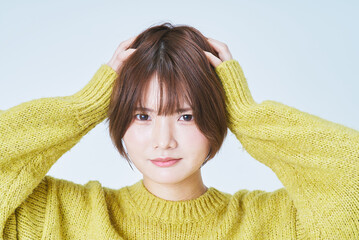 頭を抱えるショートカットの女性