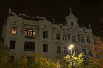 Obraz premium A large white building stands brightly illuminated at night, showcasing its elegant facade under the glow of the evening lights