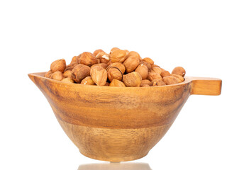 Several hazelnuts with wooden bowl, close-up, isolated on white background.