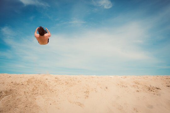 person jumping on the beach