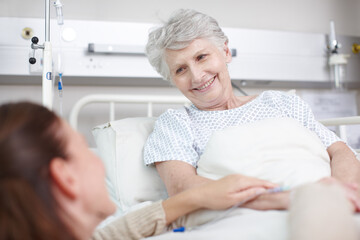 Obraz premium Family, elderly care and support in clinic for visit, healthcare services and bonding as cancer patient. Senior woman, daughter and smile in hospital for medical exam, consultation and helping hands