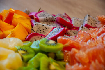 Exotic summer fruits of pineapple, dragon fruit, diospyros, grapefruit and kiwi. Exotic vitamin salad. Tropical salad. Island food. Luxury fruit mix. Tropical food. Exotic fruit. Selective focus