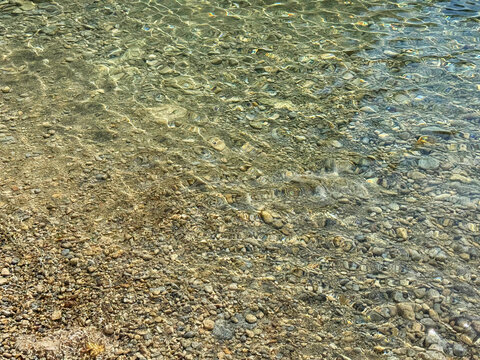 Pebbles in sea shallow clear water.