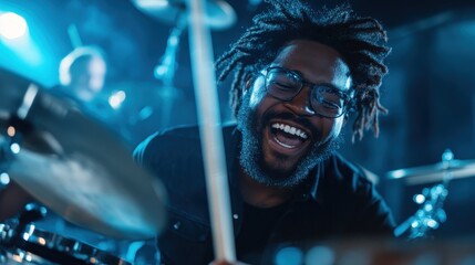 A bearded drummer with glasses passionately plays the drums, creating an energetic atmosphere under...