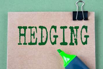 HEDGING - word on brown paper with marker on green background