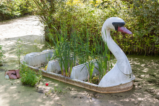 Spreepark East Berlin Germany, Abandoned swan boat in the water overgrown with plants.