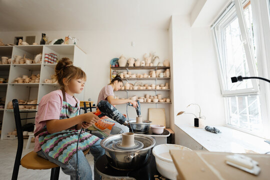 Children learn pottery skills in a bright, sunny studio space