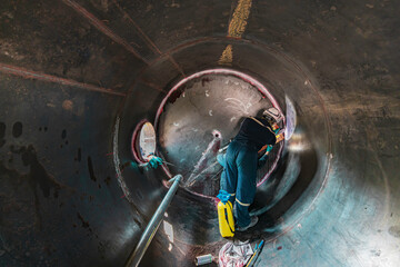 Inside male worker into the inspection shiny tank industrial construction oil and gas or storage tank oil chemical into area