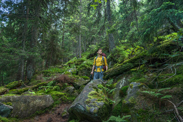 Obraz premium Young man with backpack in the deep forest enjoying hiking during the weekend.