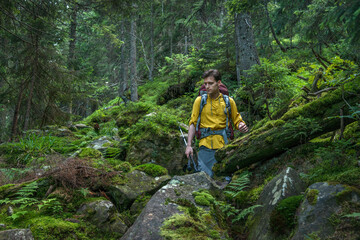 Obraz premium Young man with backpack in the deep forest enjoying hiking during the weekend.