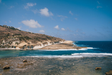 Beautiful seascape with traditional salt pans in Xwejni Bay on the island of Gozo on a sunny day, Marsaskala, Malta. 