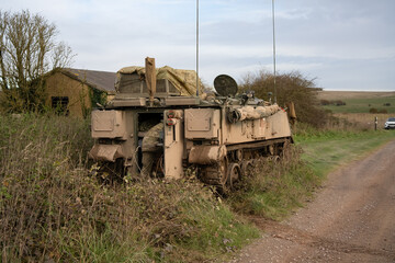 an infantry soldier climbs into the cabin of a parked Bulldog FV432 tracked troop armored personnel carrier vehicle. Wilts UK