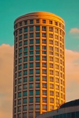 Towering Cylindrical Building with Vibrant Sunset Lighting