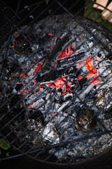 Top view of a grill grate with burning coal below