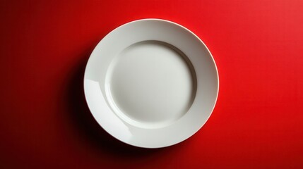 Minimalist empty plate on vibrant red background, perfect for designs.
