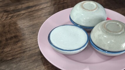 kanom tuay Thai dessert coconut milk custard in small porcelain cup .