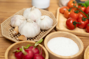 Close up in health food's Ingredients of special menu homemade cooking radish, garlic, salt, oregano, tomato and seasonings placing elements on preparing wooden table on blurred background. Postulate.