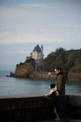 woman watching the sunset with her dog in Biarritz