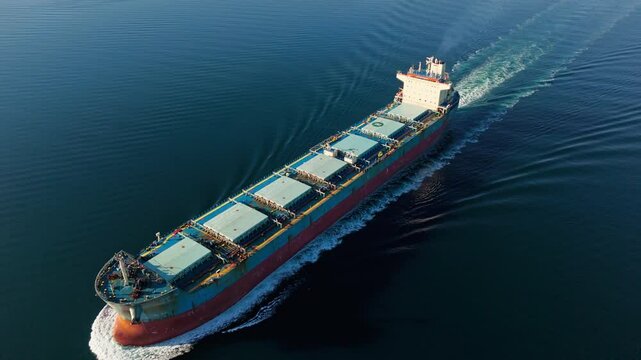 Aerial view of dry bulk carrier cargo vessel underway with high speed over sea
