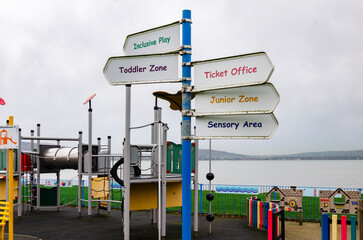 Signpost in a children's playground point to the different areas for kids