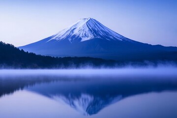Fototapeta premium Stunning View of Mount Fuji at Dawn: Serene Reflections on Misty Lake, Capturing Natures Beauty in Blue Hues and Snow-Capped Peaks