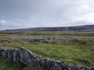 Mountainous Grassland Landscape under Cloudy Sky