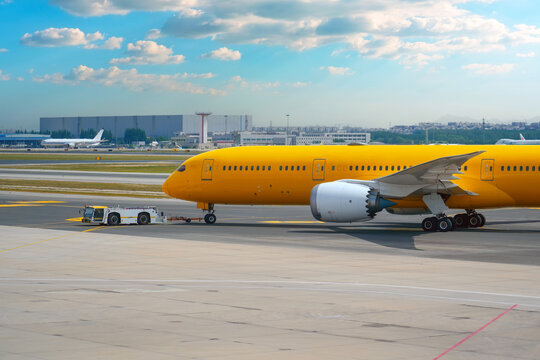 Aircraft push the tow tractor before starting the engines and taxiing, side view.