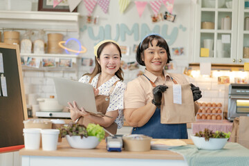 Beautiful asian sisters sell online bakery shop at home,family business,online influencer,start-up business.happyness Beautiful woman to take orders from customers,live-stream their sandwiches online
