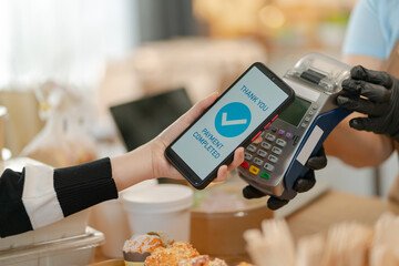 Woman Using Mobile Phone Payment to Transfer Money to bakery Shop Seller.NFC QR code device,payWave,contactless payment code for fast digital transaction,Online banking app on mobile phone,paperless
