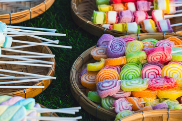 Colorful Jelly snacks on skewers in woven basket for sale in many different colors. Multi colored marshmallow and fruit jelly on sticks, dessert. Assorted colorful jelly candies. Colourful sweets.