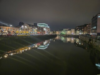 Naklejka premium Cityscape at Midnight Featuring Waterway and Tower Blocks