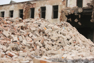 A pile of broken bricks near a building being demolished