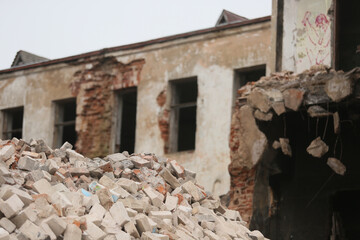 A pile of broken bricks near a building being demolished