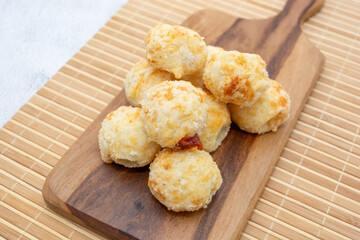 Delicious Brazilian cheese bread with sweet guava filling on a wooden serving board.