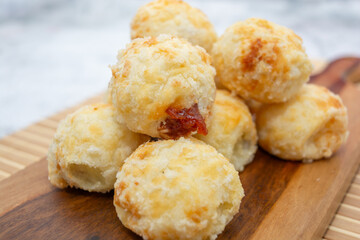 Delicious Brazilian cheese bread with sweet goiabada filling on a wooden board.