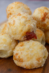 Delicious Brazilian cheese bread stuffed with goiabada on a wooden platter.