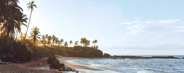 Idyllic view of Silent Beach in Tangalle, Sri Lanka, at sunrise, featuring golden sand, lush palm trees, and gentle ocean waves. Perfect for travel, nature, and serene getaway themes.