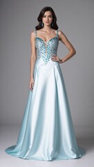 Full length satin dress adorned with aquamarine stone detailing white background 