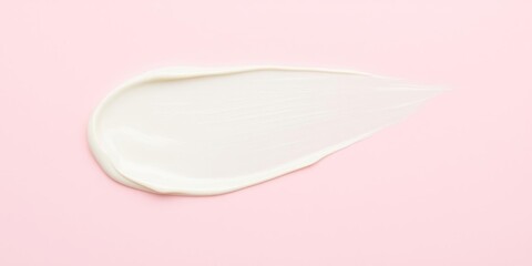 Creamy smear on a pale pink background with texture, beauty product, close-up photography