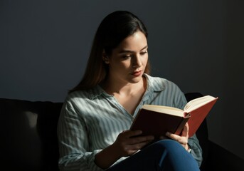 Woman Reading a Book in a Dark Room