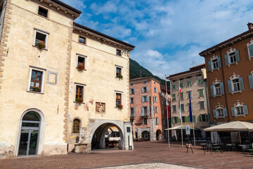 Fototapeta premium Historic town square Piazza III Novembre with Fontana di acqua potabile and palazzo Pretorio in idyllic lakeside town Riva Del Garda at lake Garda, Trentino, Italy. Mediterranean architecture