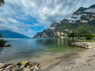 Idyllic pebble beach in lakeside town Riva Del Garda, Trentino, Northern Italy. Lake Garda is...