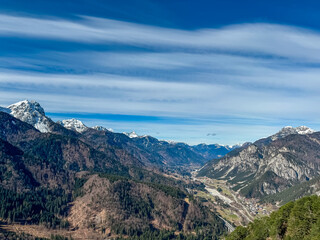 Fototapeta premium Aerial view of valley Val Canale and alpine village Malborghetto Ugovizza surrounded by snow capped mountains peaks of Julian and Carnic Alps, Friuli Venezia Giulia, Italy. Wanderlust Italian Alps