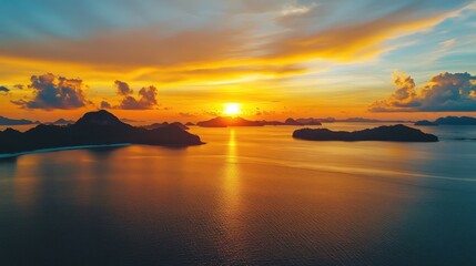 Serene sunset over tranquil sea with golden hour hues illuminating the horizon and silhouetted islands creating a picturesque landscape.
