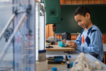Obraz premium A boy with diverse ethnicity focuses on crafting a project in a well-equipped STEM classroom, surrounded by educational tools.