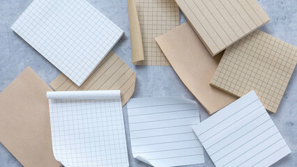 Variety of Paper Types: Lined, Grid, and Plain Sheets on a Gray Surface