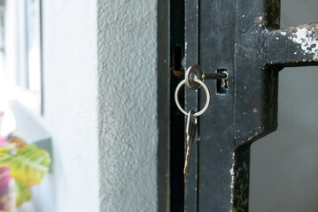 Old Keys Hanging on Dark Door Lock with White Wall Texture Background